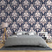 Une chambre élégante avec un papier peint damassé bleu nuit et rose, créant une atmosphère raffinée et chaleureuse.