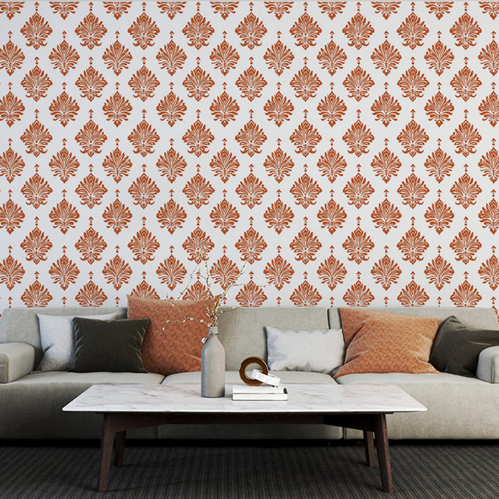 Un salon élégant avec un papier peint damassé orange sur fond blanc, créant une atmosphère chaleureuse et raffinée.