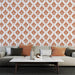 Un salon élégant avec un papier peint damassé orange sur fond blanc, créant une atmosphère chaleureuse et raffinée.