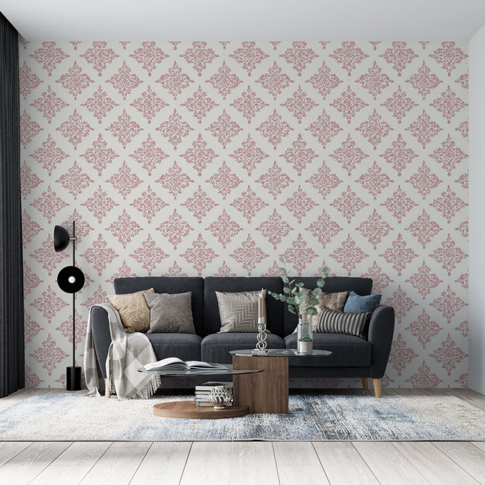 Un salon élégant avec un papier peint damassé rose sur fond clair, créant une atmosphère chaleureuse et raffinée.