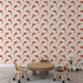 Une chambre d'enfant avec un papier peint illustrant des dauphins en rouge sur fond beige, créant une ambiance ludique et joyeuse.
