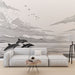 Un salon moderne avec un papier peint représentant des dauphins en mouvement sur fond de paysage marin stylisé en noir et blanc, créant une ambiance apaisante et artistique.