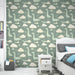Une chambre d'enfant avec un papier peint ludique représentant des dinosaures verts et des nuages sur un fond bleu-vert, créant une ambiance joyeuse et imaginative.