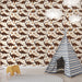 Une chambre d'enfant avec un papier peint illustrant des dinosaures marron sur fond crème, créant une atmosphère ludique et chaleureuse.