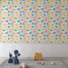 Une chambre d'enfant avec un papier peint ludique illustrant des dinosaures colorés sur fond clair, créant une ambiance joyeuse et imaginative.
