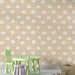 Une chambre d'enfant avec un papier peint beige orné de petits éléphants blancs et d'étoiles, créant une ambiance douce et ludique.