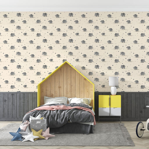Une chambre d'enfant avec un papier peint illustré de petits éléphants gris sur fond crème, créant une atmosphère douce et ludique.