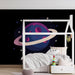 Une chambre d'enfant avec un papier peint spatial représentant une planète bleue entourée d'anneaux roses sur fond noir, créant une ambiance imaginative et ludique.
