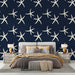 Une chambre élégante avec un papier peint marine représentant des étoiles de mer blanches sur fond bleu nuit, créant une ambiance apaisante et estivale.