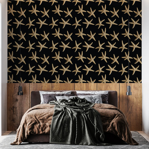 Une chambre moderne avec un papier peint noir orné d'étoiles de mer dorées, créant une atmosphère marine élégante et originale.