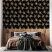 Une chambre moderne avec un papier peint noir orné d'étoiles de mer dorées, créant une atmosphère marine élégante et originale.
