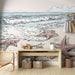 Une pièce lumineuse avec un papier peint illustrant une plage paisible, des étoiles de mer et des vagues stylisées sur un fond pastel apaisant.