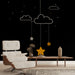 Une chambre moderne avec un papier peint noir illustrant des nuages et des étoiles suspendues, créant une ambiance rêveuse et apaisante.