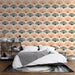 Une chambre moderne avec un papier peint aux motifs de éventails en dégradé de pêche et noir, créant une ambiance élégante et chaleureuse.