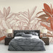 Une chambre moderne avec un papier peint aux motifs de feuilles stylisées en rouge et beige, créant une ambiance chaleureuse et naturelle.