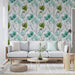 Un salon lumineux avec un papier peint floral aux motifs de feuilles aquatiques vertes et turquoise sur fond clair, créant une atmosphère fraîche et apaisante.
