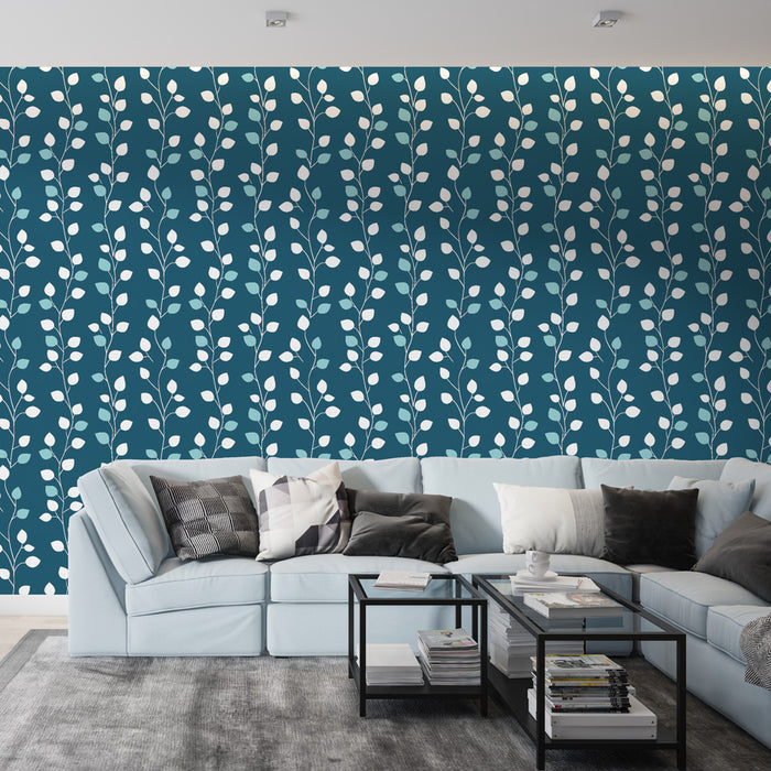 Un salon moderne avec un papier peint bleu profond orné de motifs de feuilles blanches et vertes, créant une atmosphère apaisante et naturelle.