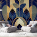 Un salon moderne avec un papier peint aux motifs botaniques stylisés en bleu et or, créant une ambiance élégante et chaleureuse.