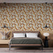 Une chambre moderne avec un papier peint floral aux motifs de feuilles et de baies dans des teintes chaudes de beige, orange et marron, créant une ambiance accueillante et chaleureuse.