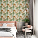 Une chambre moderne avec un papier peint aux motifs de feuilles stylisées dans des teintes vertes, brunes et beiges, créant une ambiance naturelle et apaisante.