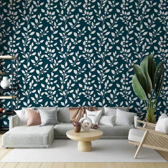 Un salon moderne avec un papier peint bleu canard orné de motifs de feuilles blanches, créant une atmosphère apaisante et élégante.