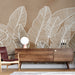Une pièce moderne avec un papier peint représentant de grandes feuilles blanches sur fond marron, créant une atmosphère chaleureuse et naturelle.