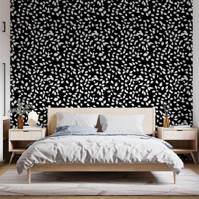 Une chambre moderne avec un papier peint noir orné de délicates feuilles blanches, créant une ambiance élégante et contemporaine.