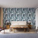 Une chambre moderne avec un papier peint aux motifs de feuillages dans des teintes de bleu et vert sur fond clair, créant une atmosphère fraîche et apaisante.