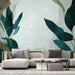 Un salon moderne avec un papier peint aux motifs de grandes feuilles stylisées dans des teintes de vert et de bleu, créant une atmosphère apaisante et naturelle.