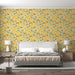 Une chambre moderne avec un papier peint aux motifs de feuilles colorées dans des teintes jaunes, vertes et orange, créant une ambiance joyeuse et chaleureuse.