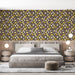 Une chambre moderne avec un papier peint aux motifs de feuilles colorées dans des teintes de violet, jaune et crème sur fond marron, créant une ambiance chaleureuse et accueillante.
