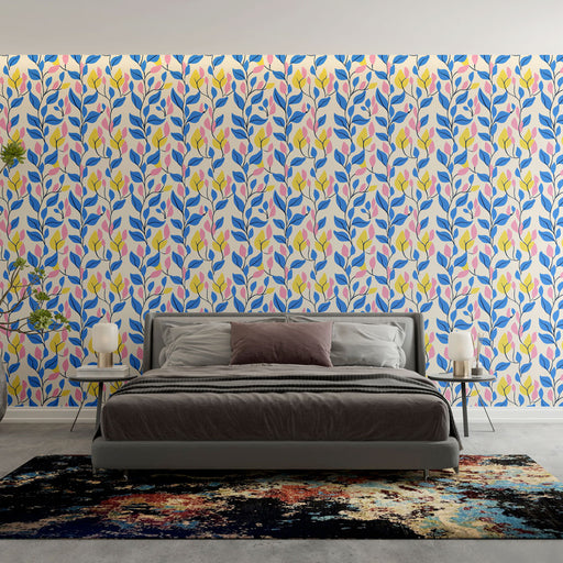 Une chambre moderne avec un papier peint floral aux motifs de feuilles bleues, roses et jaunes sur fond clair, créant une ambiance joyeuse et dynamique.