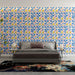 Une chambre moderne avec un papier peint floral aux motifs de feuilles bleues, roses et jaunes sur fond clair, créant une ambiance joyeuse et dynamique.