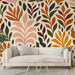 Un salon moderne avec un papier peint aux motifs de feuillage coloré dans des teintes chaudes de rouge, orange et vert sur fond crème, créant une ambiance accueillante et dynamique.
