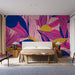 Papier peint feuillage coloré avec motifs floraux vibrants sur fond rose pour chambre moderne.
