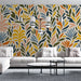 Un salon moderne avec un papier peint aux motifs de feuillage coloré dans des teintes chaudes et fraîches, créant une ambiance vivante et accueillante.