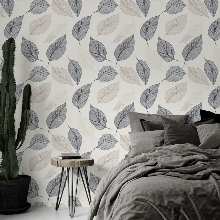 Une chambre apaisante avec un papier peint aux motifs de feuilles délicates dans des teintes de gris et beige sur fond clair.