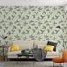 Un salon moderne avec un papier peint aux motifs de feuilles délicates sur fond vert clair, créant une ambiance naturelle et apaisante.