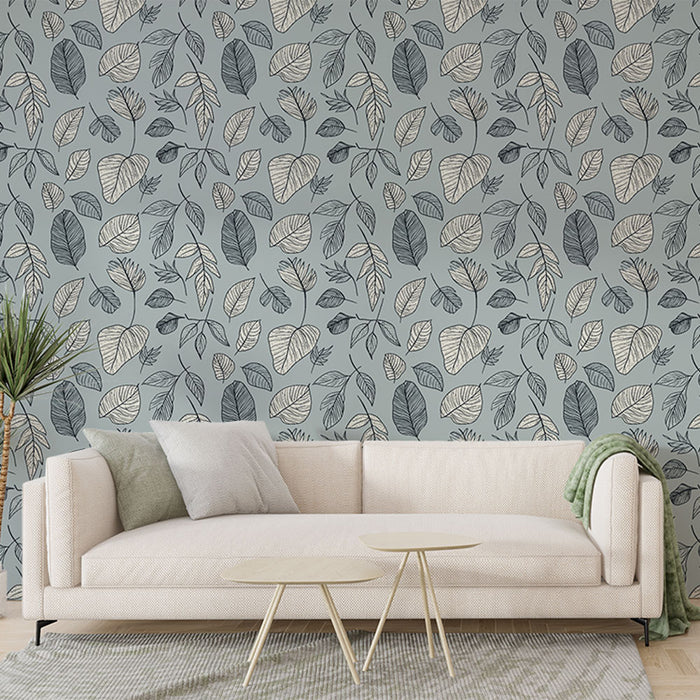 Un salon moderne avec un papier peint aux motifs de feuilles délicates en noir et beige sur fond bleu, créant une ambiance apaisante et naturelle.
