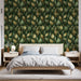 Une chambre moderne avec un papier peint aux motifs de feuilles dorées et vertes sur fond sombre, créant une atmosphère apaisante et naturelle.