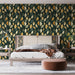 Une chambre élégante avec un papier peint aux motifs de feuilles stylisées dans des teintes vertes, dorées et crème, créant une atmosphère chaleureuse et naturelle.