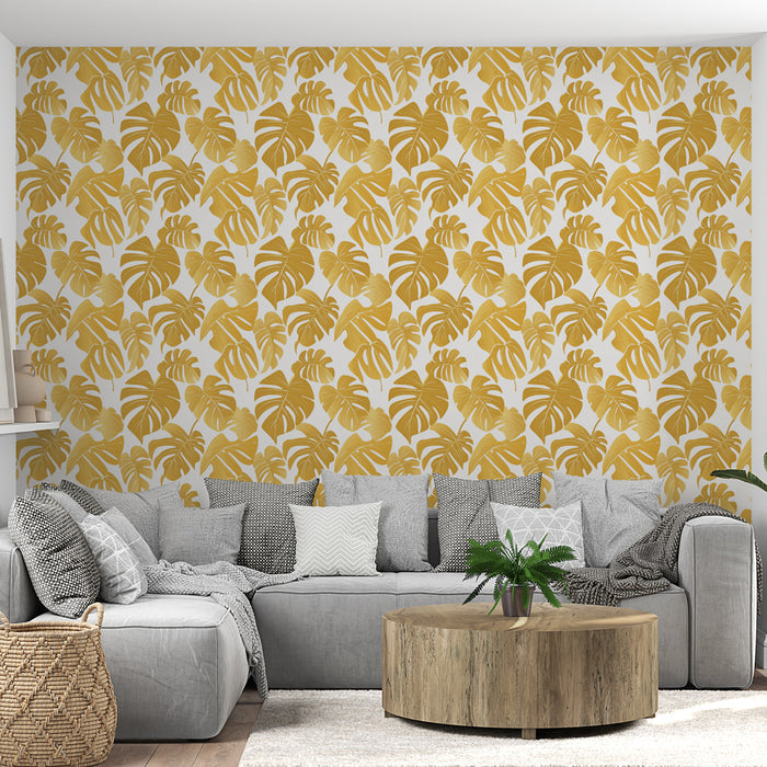Un salon moderne avec un papier peint tropical aux motifs de grandes feuilles dorées sur fond blanc, créant une ambiance chaleureuse et élégante.