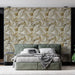 Une chambre moderne avec un papier peint aux motifs de feuilles dorées et beiges sur fond clair, créant une atmosphère élégante et apaisante.