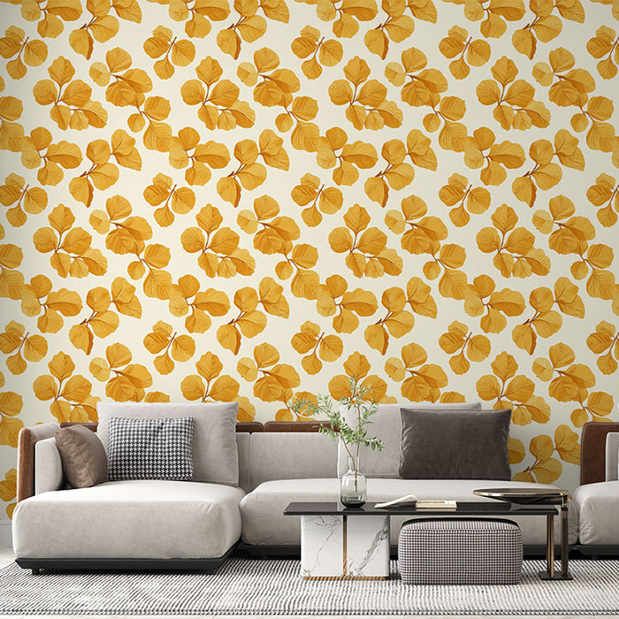 Un salon moderne avec un papier peint aux motifs de feuilles dorées sur fond crème, créant une ambiance chaleureuse et accueillante.