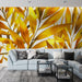 Un salon moderne avec un papier peint aux motifs de feuilles dorées sur fond blanc, créant une ambiance chaleureuse et dynamique.