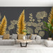 Un salon moderne avec un papier peint représentant des feuilles dorées sur fond gris, créant une ambiance élégante et chaleureuse.