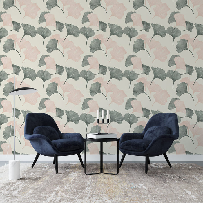 Un salon moderne avec un papier peint aux motifs de feuilles de ginkgo en vert et rose sur fond crème, créant une ambiance douce et apaisante.