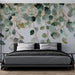Une chambre moderne avec un papier peint représentant des feuilles délicates aux teintes vertes et dorées, créant une ambiance apaisante et naturelle.