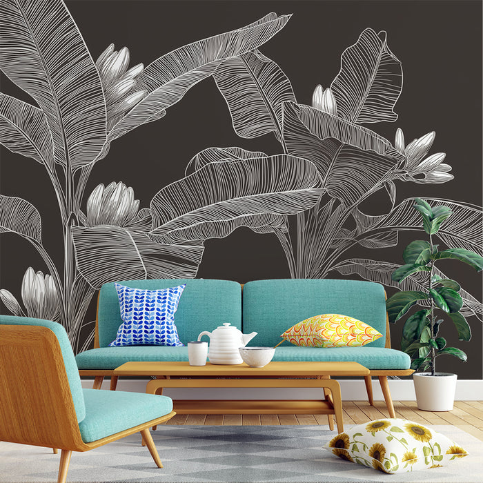 Un salon moderne avec un papier peint noir illustré de grandes feuilles blanches et de fleurs, créant une ambiance tropicale et élégante.