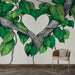 Une pièce moderne avec un papier peint représentant des feuilles vertes stylisées et des branches formant un cœur, créant une ambiance naturelle et chaleureuse.